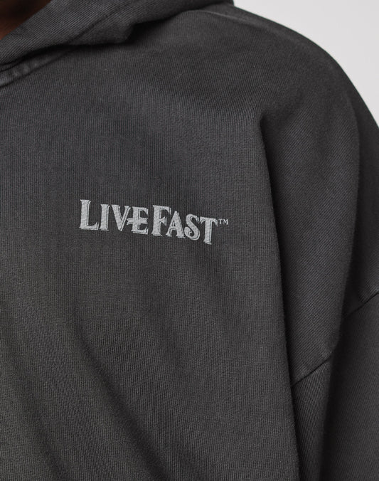 Close-up of the LFDY Loyal Hooded Zip by LIVE FAST DIE YOUNG, a dark hoodie with Vintage Waschung and LIVE FAST™ in white on the chest, made from 100% Baumwolle in an Oversize Fit.