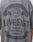 A person wears a gray LFDY Loyal Tee by LIVE FAST DIE YOUNG featuring “With us or against us. Living faster. The Good Life Established 2012. Live Fast.” Oversize fit, 100% Baumwolle, with Germany, UK, and Netherlands listed.