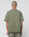 A person with a shaved head stands with their back to the camera, wearing an olive green LIVE FAST DIE YOUNG Basic +49 Tee and matching 100% cotton shorts. Their tattooed arms hang loosely by their sides.