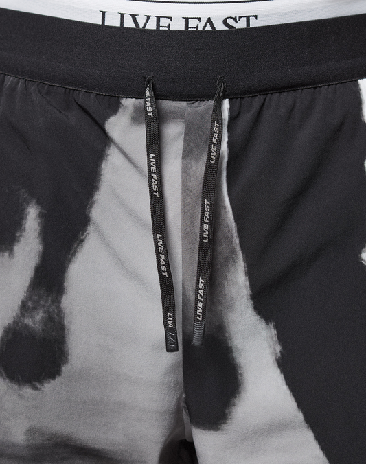 Close-up of LFDY Performance Shorts by LIVE FAST DIE YOUNG in black and white tie-dye, featuring a reflective LIVE FAST logo on the black drawstrings, a white waistband with black LIVE FAST text, regular fit, and lightweight fabric for comfort.