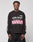 A man wears the LFDY Racing Longsleeve by LIVE FAST DIE YOUNG—an oversized black shirt with “LIVE FAST Everything in it.”, pink stripes, bold white sleeve text, 100% Baumwolle, and reflektierendem Print—set against a plain light background.