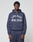 A man faces forward in a navy LFDY Heavyweight Lounge Hooded sweatshirt and matching sweatpants by LIVE FAST DIE YOUNG. The Regular Fit 100% Baumwolle hoodie displays "LIVE FAST REAL EST.8" in large white letters on a plain light background.