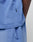 Close-up of a person wearing the LIVE FAST DIE YOUNG Basic +49 Tee in an oversize fit light blue, featuring a visible pocket and a small black flag-label with white text on the side seam. Only part of the arm and torso are shown.