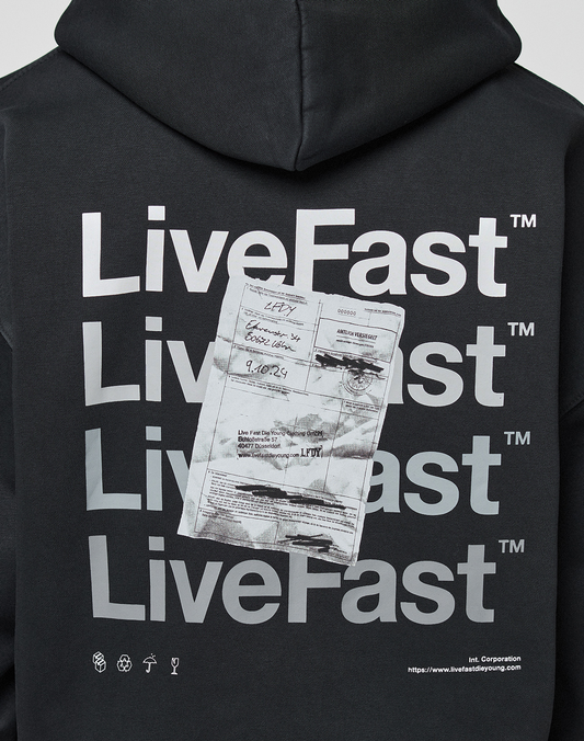 The Basic Evidence Hooded Zip by LIVE FAST DIE YOUNG is a black, oversized hoodie featuring repeated white LiveFast™ text and a printed document image on the back, small symbols, LFDY branding, and a website link at the bottom right.