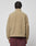 A person with short, twisted hair is seen from behind wearing the tan LFDY Teddy Jacket by LIVE FAST DIE YOUNG in Oversize Fit and maroon pants, standing against a plain light gray background.