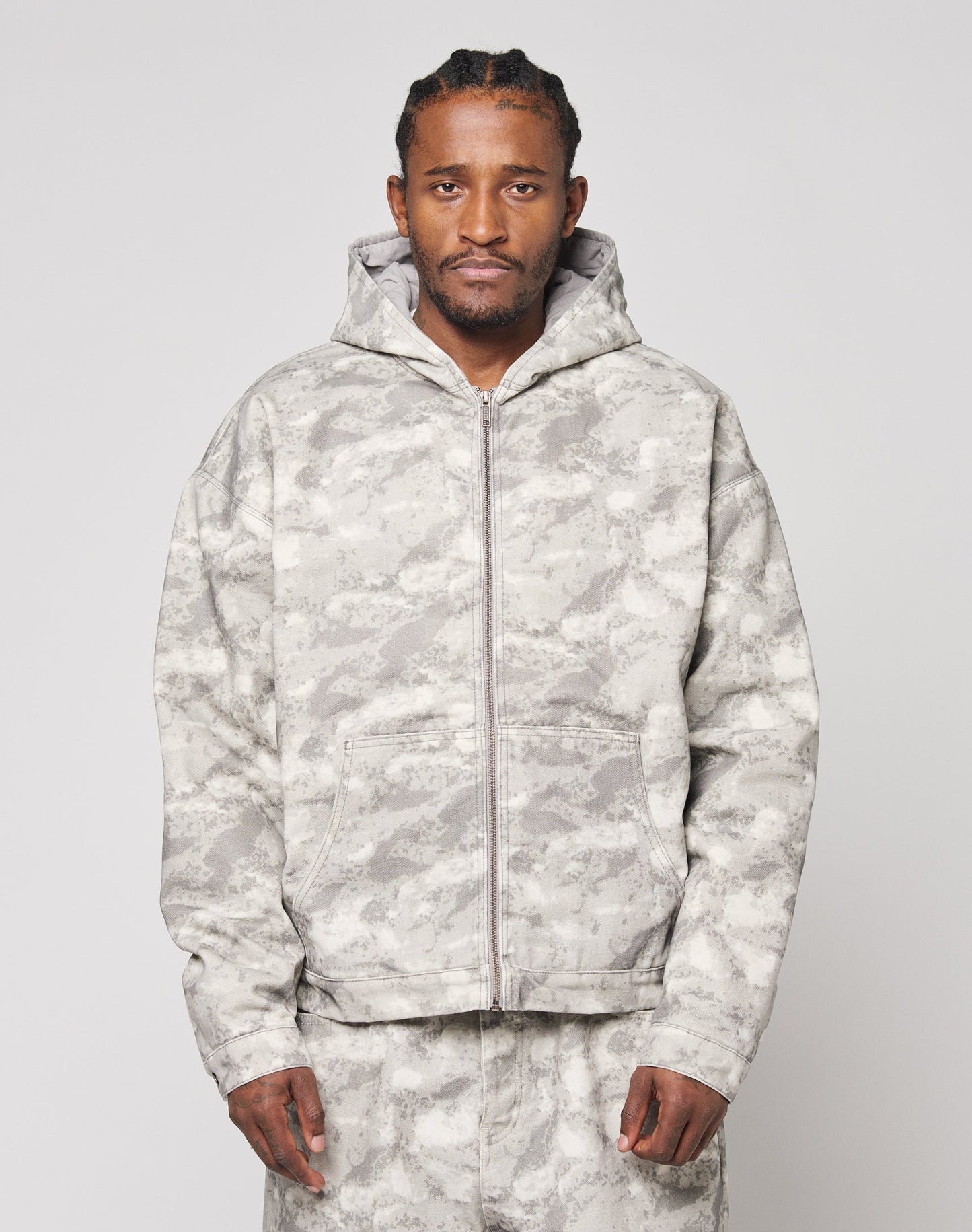 A man stands facing forward against a plain light background, wearing the LIVE FAST DIE YOUNG Live Fast Canvas Jacket in an oversize fit with a light gray camouflage pattern and matching pants.