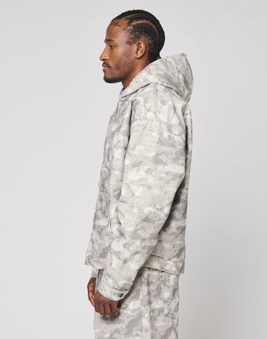 A man with braided hair stands in profile against a plain white background, wearing an oversize fit Live Fast Canvas Jacket by LIVE FAST DIE YOUNG.