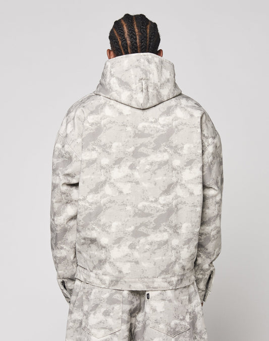 A person with braided hair is seen from behind, wearing the LIVE FAST DIE YOUNG Live Fast Canvas Jacket and matching pants in a light gray camouflage pattern against a plain background.