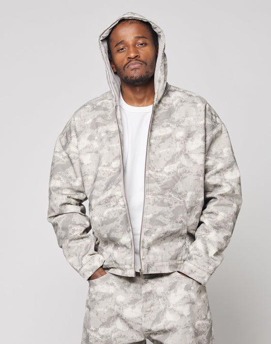 A man wears the LIVE FAST DIE YOUNG Live Fast Canvas Jacket with matching pants, standing confidently with hands in pockets against a plain light background.