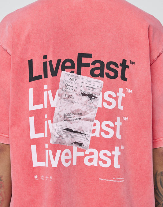 Someone wearing the LIVE FAST DIE YOUNG Basic Evidence Tee in pink, made from 100% Baumwolle. The oversize shirt features faded receipt-style graphics and repeated black-and-white LiveFast text on the back.