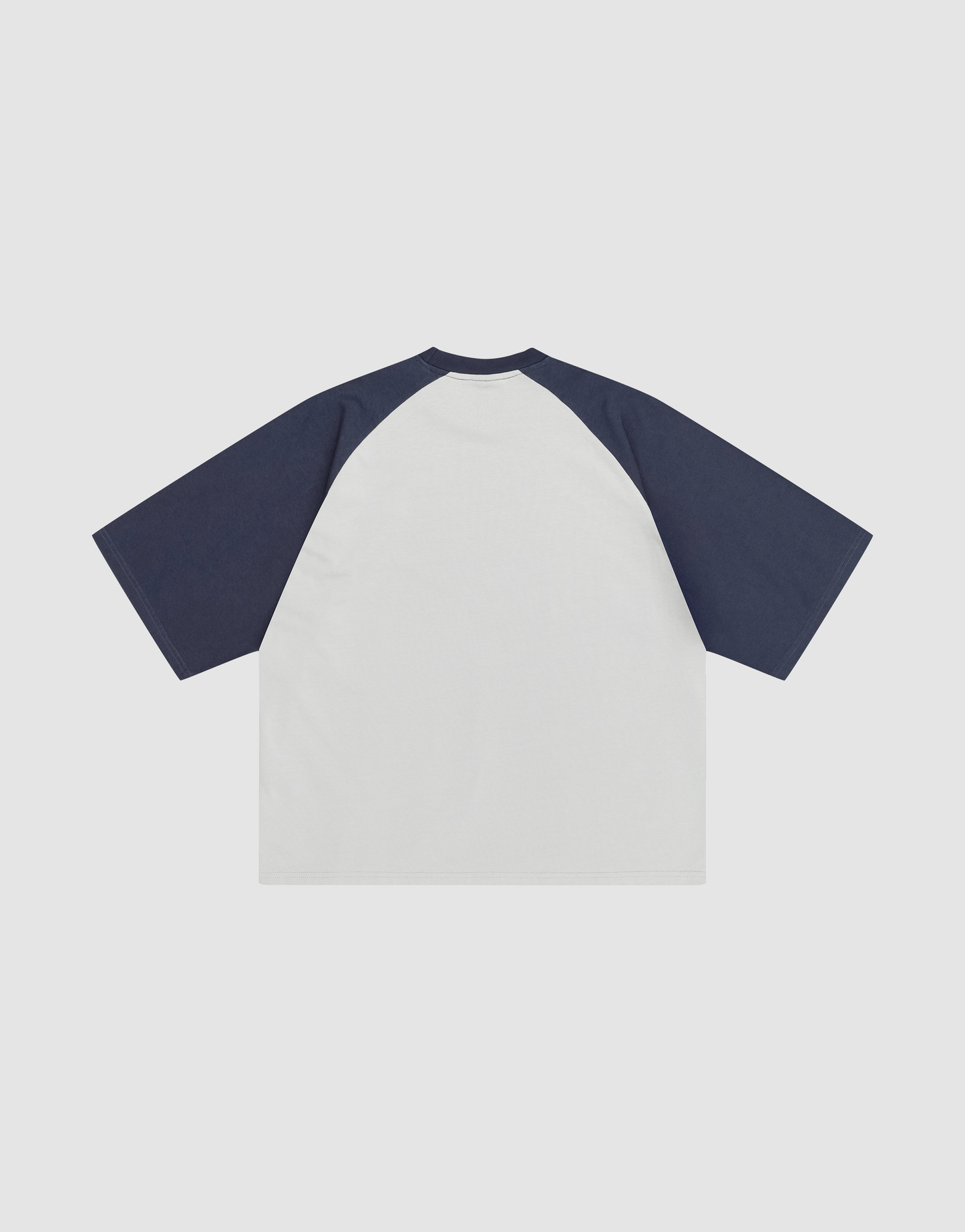 The LIVE FAST DIE YOUNG Live Fast Raglan Tee features a white body with dark navy raglan sleeves, crafted from 100% cotton. Displayed flat on a white background, the image shows the back view of this short-sleeve tee.