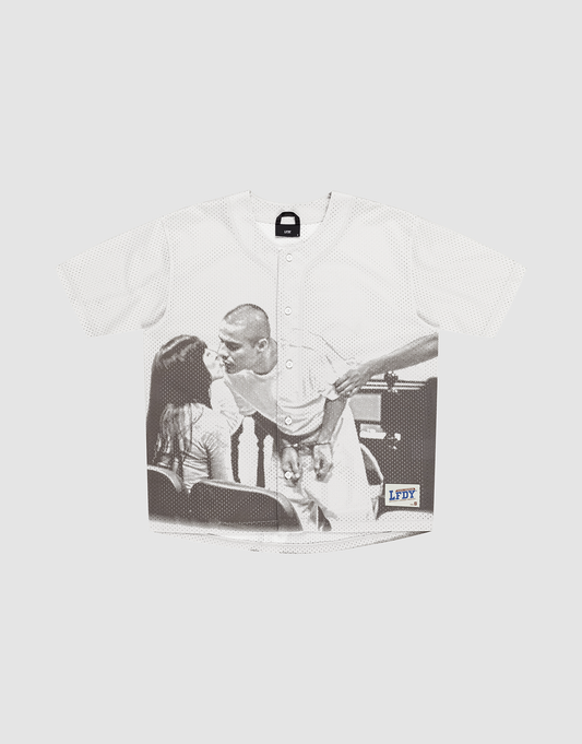 The LFDY Courtroom Jersey by LIVE FAST DIE YOUNG is a white oversized baseball jersey with a black-and-white photo of a man kissing a woman and features a small blue and yellow LFDY logo near the hem. | plain