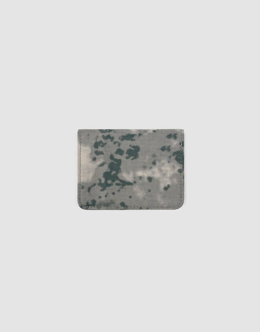 The LFDY Cardholder by LIVE FAST DIE YOUNG is a compact, rectangular women’s wallet with a gray and dark green abstract camo pattern and practical card slots, displayed on a plain light gray background.