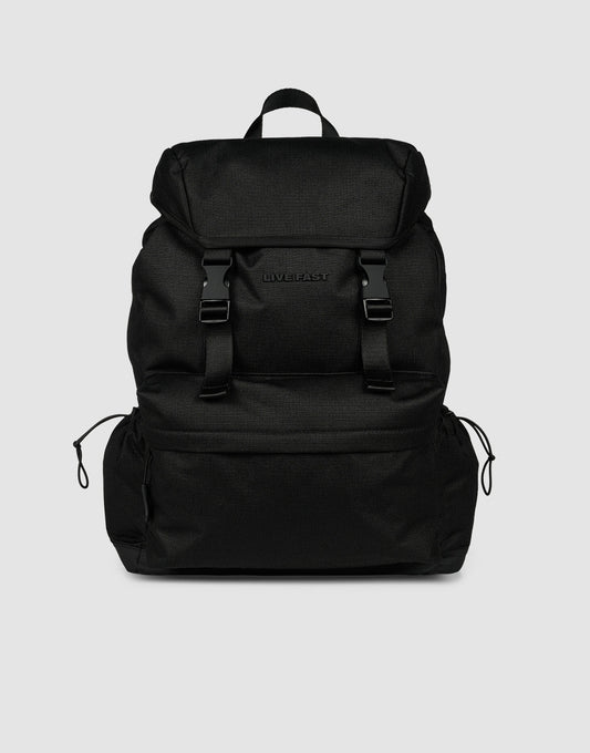 The LFDY Travel Backpack by LIVE FAST DIE YOUNG is a black 25L rucksack featuring adjustable shoulder straps, a top flap, two front buckles, side drawstring pockets, and a top handle, shown against a plain light gray background.| plain 