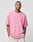 A man stands against a plain light background wearing an oversize-fit, pink LFDY Loyal Tee by LIVE FAST DIE YOUNG with partial LIVFR on the chest and light-colored pants. His neck and arm tattoos are visible as his hands rest in his pockets.