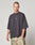 A man with short hair wears the Live Fast Cropped Oversized Tee by LIVE FAST DIE YOUNG, featuring a small white chest graphic and paired with light tan camo pants, standing against a plain light gray background.