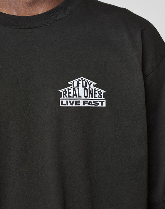A close-up of the LFDY Real Ones Tee by LIVE FAST DIE YOUNG, a black T-shirt with a white "LFDY REAL ONES LIVE FAST" chest graphic. Crafted from 100% Baumwolle in an Oversize Fit for maximum comfort.