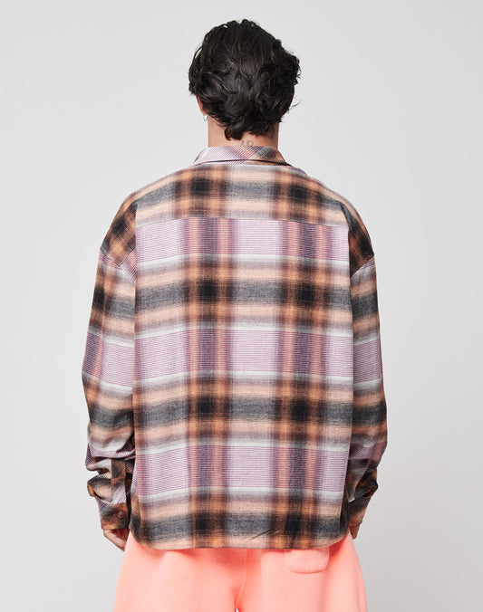 Seen from behind, a person with short, wavy dark hair wears the LIVE FAST DIE YOUNG Loose Summer Flannel—an oversize-fit shirt in pink, brown, and black plaid made from 100% Baumwolle—paired with light pink pants against a plain background.