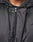 Close-up of a person in the LIVE FAST DIE YOUNG LFDY Winter Bomber Jacket, showing only the lower face, neck, and chest. The shiny black polyester features a hood with metal eyelets and toggles for an Oversize Fit look.