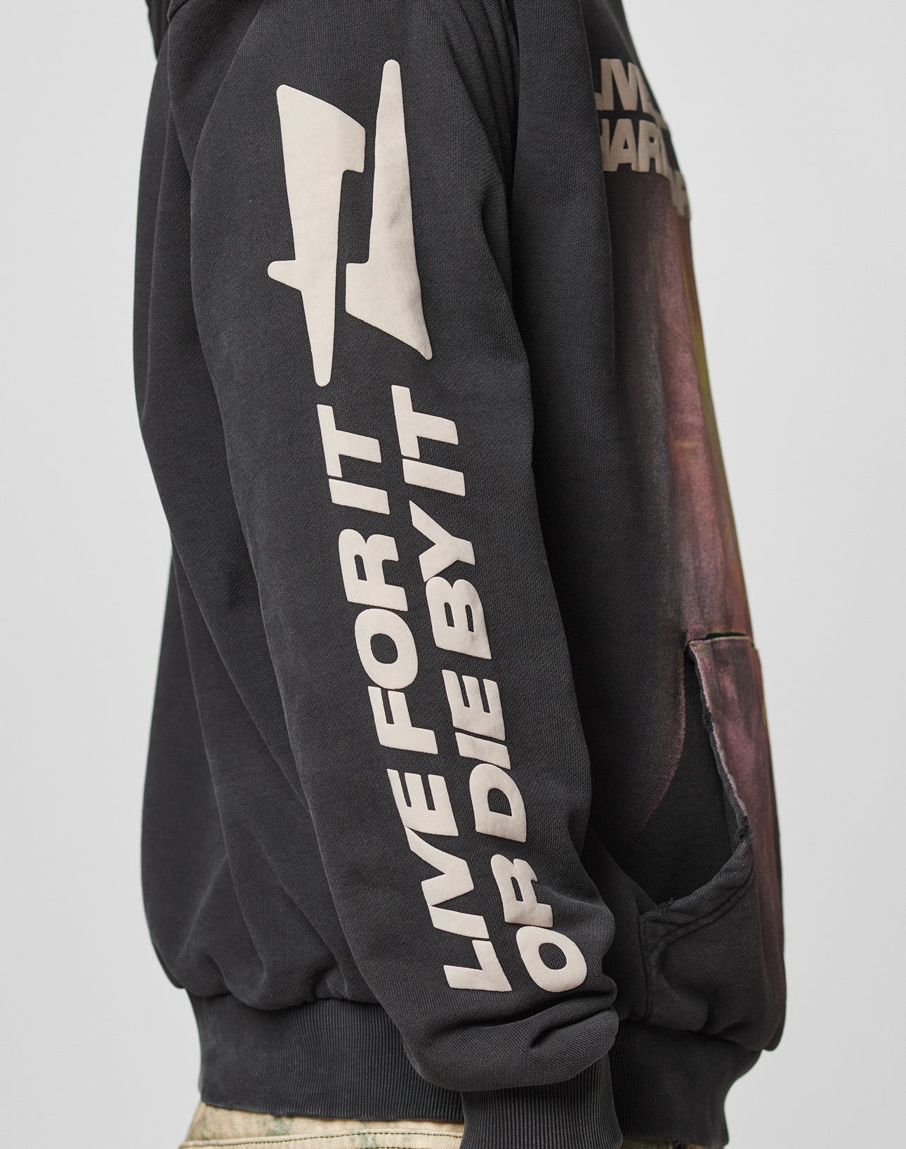 A person wears the LFDY Angel Hooded by LIVE FAST DIE YOUNG, an oversize black 100% cotton hoodie with bold white “LIVE FOR IT OR DIE BY IT” text, plus a graphic and distressed-effect logo on sleeve and chest.