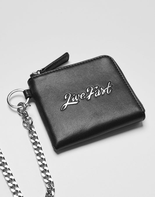 The Live Fast Wallet by LIVE FAST DIE YOUNG is a black leather wallet with a silver chain and Live Fast in metallic script on the front, plus bold branding.