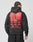 A person wearing the LIVE FAST DIE YOUNG Hit and Run Hooded, an oversized black hoodie with a large cracked backprint showing a hand holding a match, bold LIVE FAST and HIT AND RUN text, smaller details, and country names.