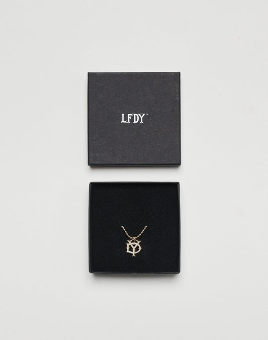The DY Chain by LIVE FAST DIE YOUNG is a gold-plated sterling silver necklace with an intertwined LFDY pendant, presented in a black jewelry box with a matching lid featuring white LFDY lettering, displayed on a white background.