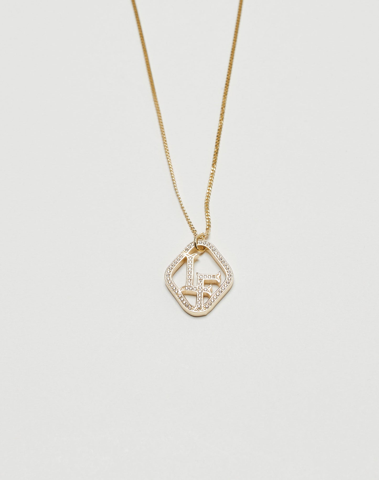 The LF Chain by LIVE FAST DIE YOUNG is a vergoldet necklace with a thin chain and geometric key-and-keyhole pendant, accented with Zirkonia Steinen, shown on a plain white background.