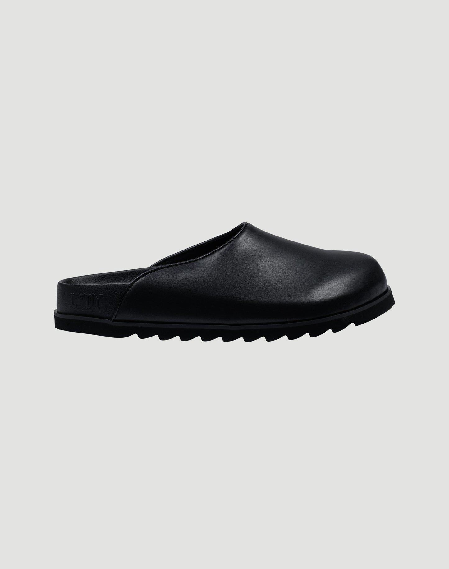 The LFDY Mules by LIVE FAST DIE YOUNG are black slip-on mule shoes with a rounded toe, flat back, thick ridged EVA sole, and schwarze Innenmaterial, shown against a plain light grey background.
