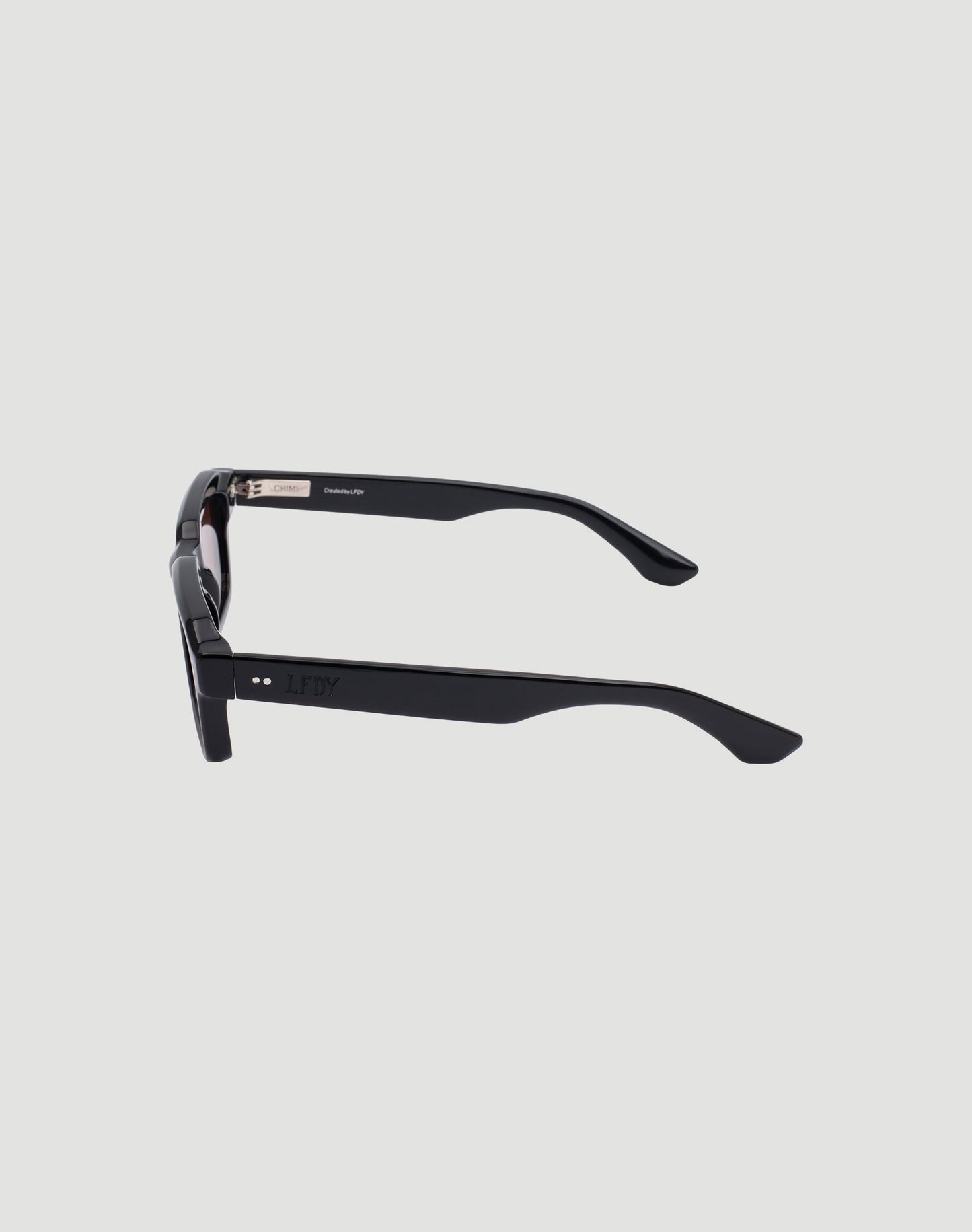 Side view of LIVE FAST DIE YOUNG LFDY x Chimi Shades 03 in black with thick rectangular frames, CR39 lenses, and slightly curved arms, set against a plain light gray background.