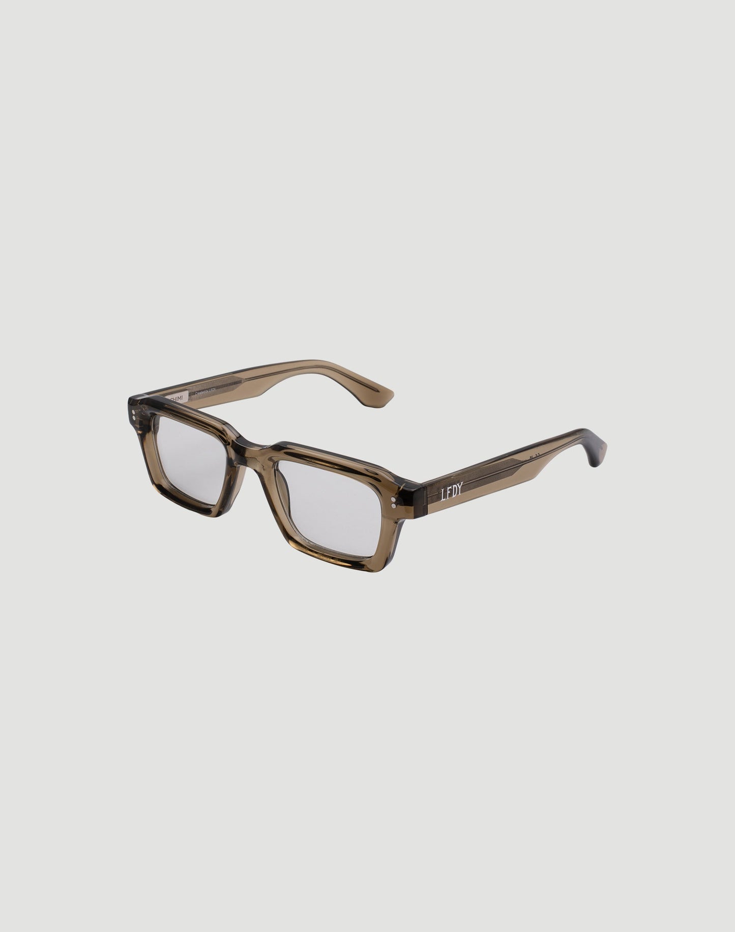 The LFDY x Chimi Shades 03 by LIVE FAST DIE YOUNG are translucent brown rectangular eyeglasses with thick acetate frames and clear lenses, shown at an angle on a plain white background highlighting front and side details.