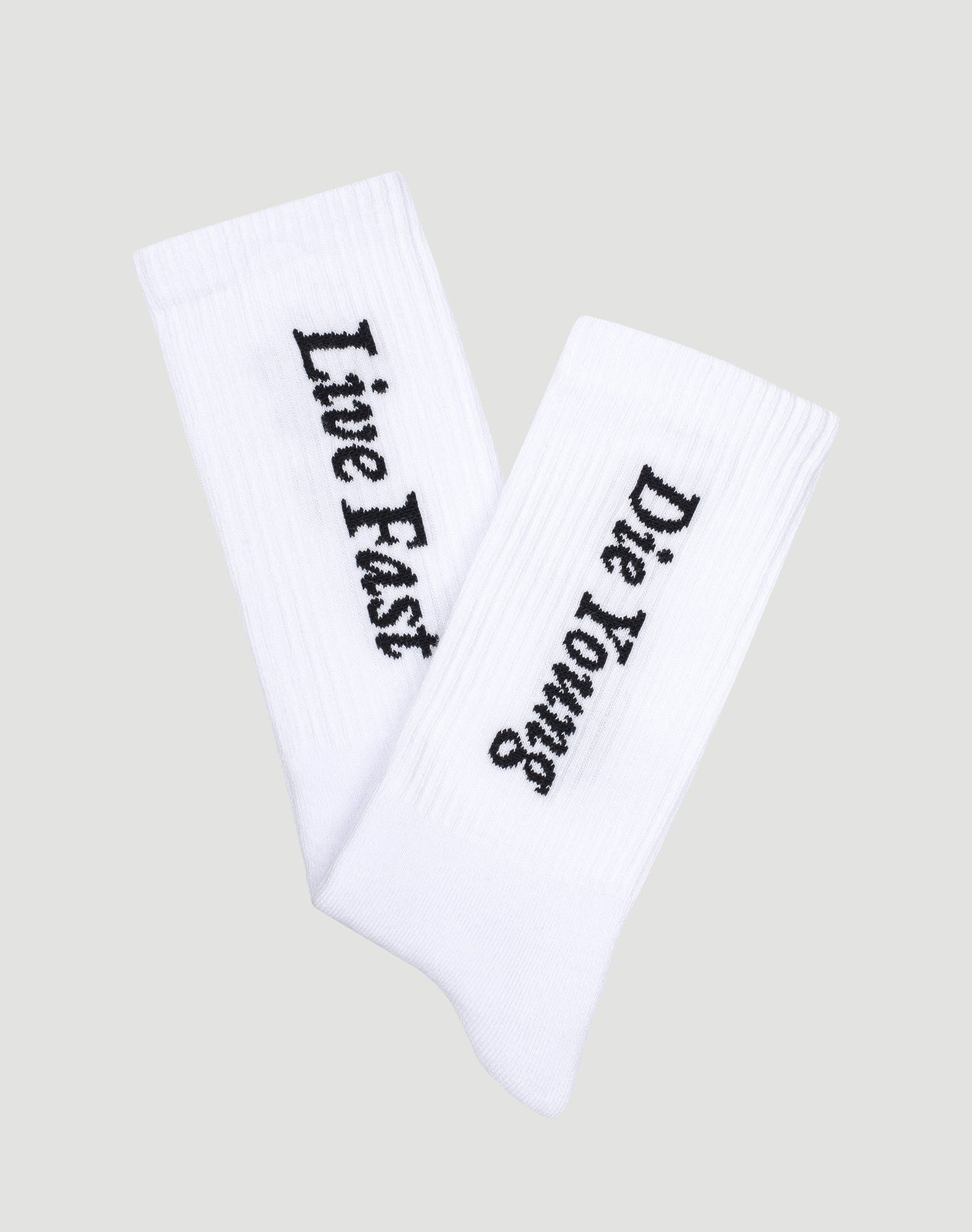 The LIVE FAST DIE YOUNG Live Fast Die Young Socks (2 Pack) feature white ribbed socks with black Live Fast and Die Young text, crafted from a comfortable Baumwolle, Polyamid, and Elastan blend, shown on a light gray background.| plain