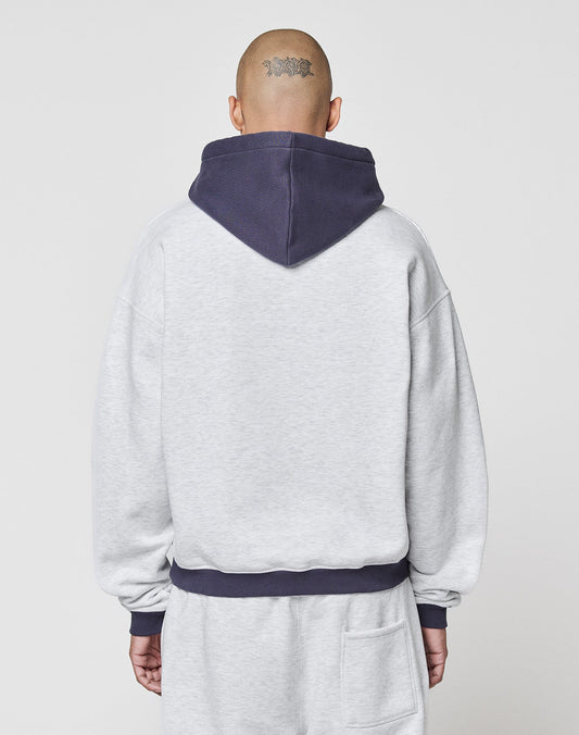 A person with a shaved head and a tattoo on the back wears the LFDY District Hooded by LIVE FAST DIE YOUNG in light gray with contrast hood and cuffs, shown from behind against a plain light background.