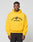 A man wearing a bright yellow LIVE FAST DIE YOUNG Live Fast Beware Hooded with LIVE FAST BEWARE and a fierce animal graphic on the front stands against a plain light gray background.