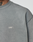 Close-up of a person wearing the faded gray Basic Trademark Tee by LIVE FAST DIE YOUNG, featuring 100% Baumwolle, an oversize fit, and small white LFDY™ letters on the chest. Part of their neck and a tattoo are visible.