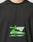 Close-up of a person wearing the LFDY Sports Longsleeve by LIVE FAST DIE YOUNG, a black shirt with raglan sleeves, featuring a green stylized airplane logo and bold green LIVE FAST™ text.