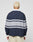 A person with short, bleached blonde hair faces away, wearing the LFDY Striped Polo by LIVE FAST DIE YOUNG—an oversize fit navy long-sleeve with light gray stripes—paired with cream pants, against a plain light background.