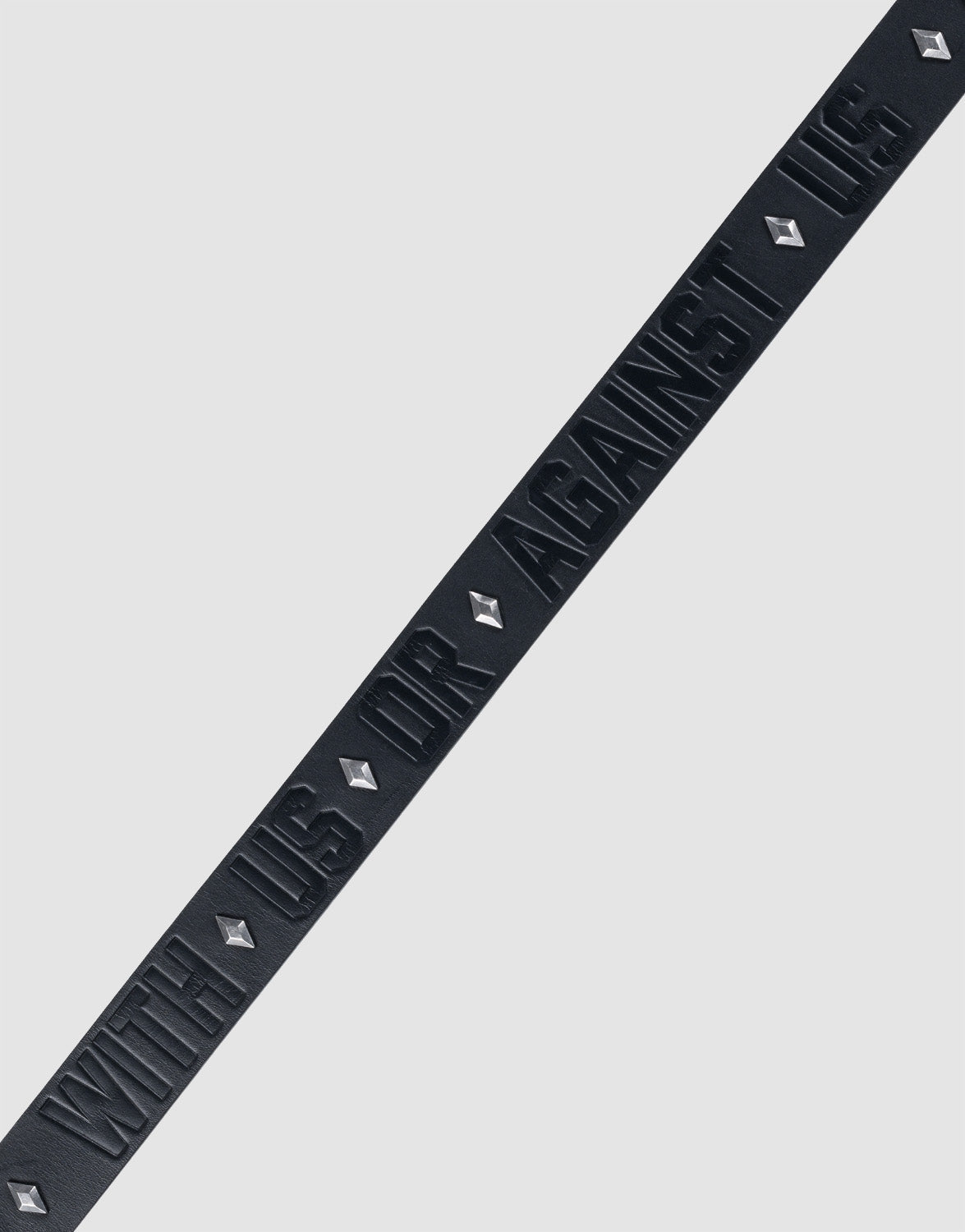The LFDY Signature Belt by LIVE FAST DIE YOUNG features a black diagonal strip with raised "WITH US OR AGAINST US" text and diamond-shaped Nieten, all set against a plain light gray background.