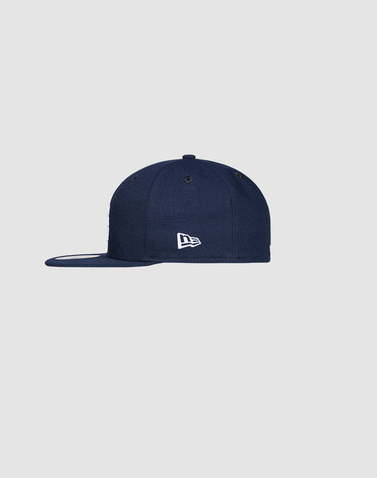 A navy blue LFDY x New Era 59FIFTY Paris fitted cap by LIVE FAST DIE YOUNG, shown from the side with a small white embroidered logo on the side panel, set against a plain light grey background.