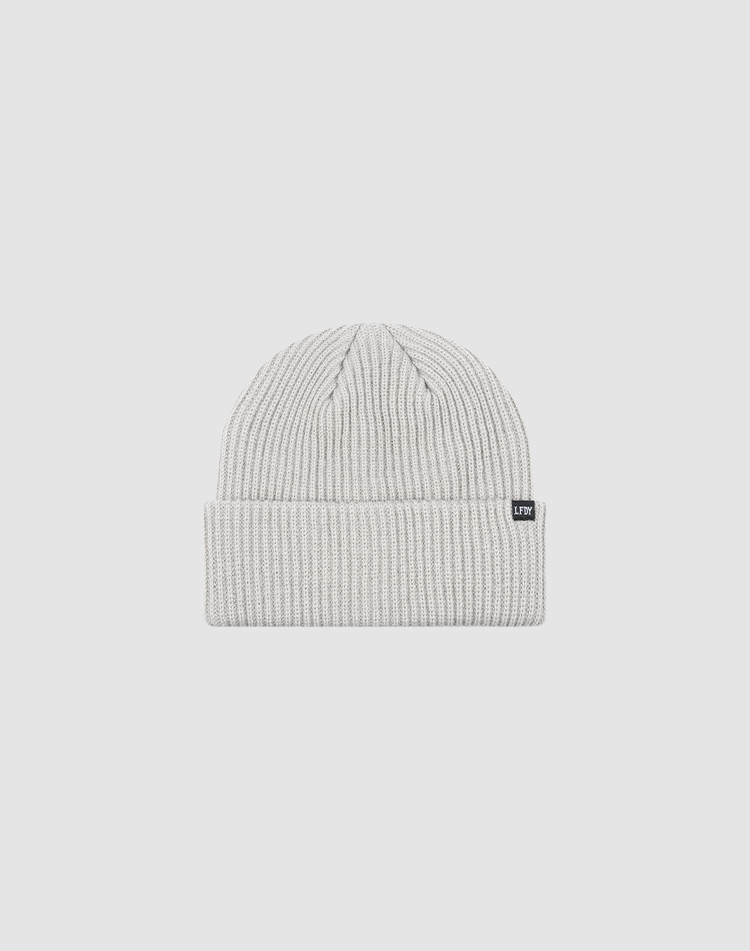 The Double Rib Knit Beanie by LIVE FAST DIE YOUNG is a light gray, doppellagig gestrickt hat with a folded cuff and a small black rectangular tag, shown on a plain white background.