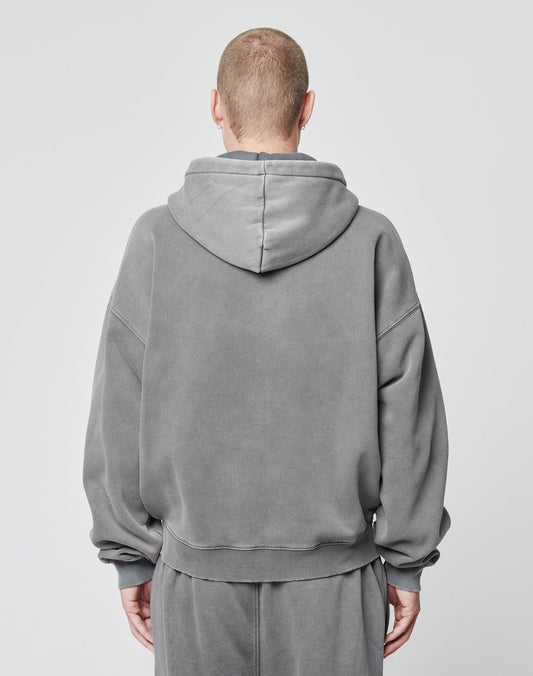 A person with short hair faces away from the camera, wearing a loose-fitting LIVE FAST DIE YOUNG Basic Script Hooded Zip and matching sweatpants in vintage wash against a plain light background.