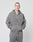 A person with short hair wears a matching grey LIVE FAST DIE YOUNG Basic Script Hooded Zip and sweatpants with Logo-Stick, facing the camera with hands in hoodie pockets against a plain light background.