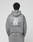 A person wears the Basic Evidence Hooded by LIVE FAST DIE YOUNG, an oversize gray hoodie with “Live Fast” repeated in white and a crumpled paper graphic on the back, shown from behind.