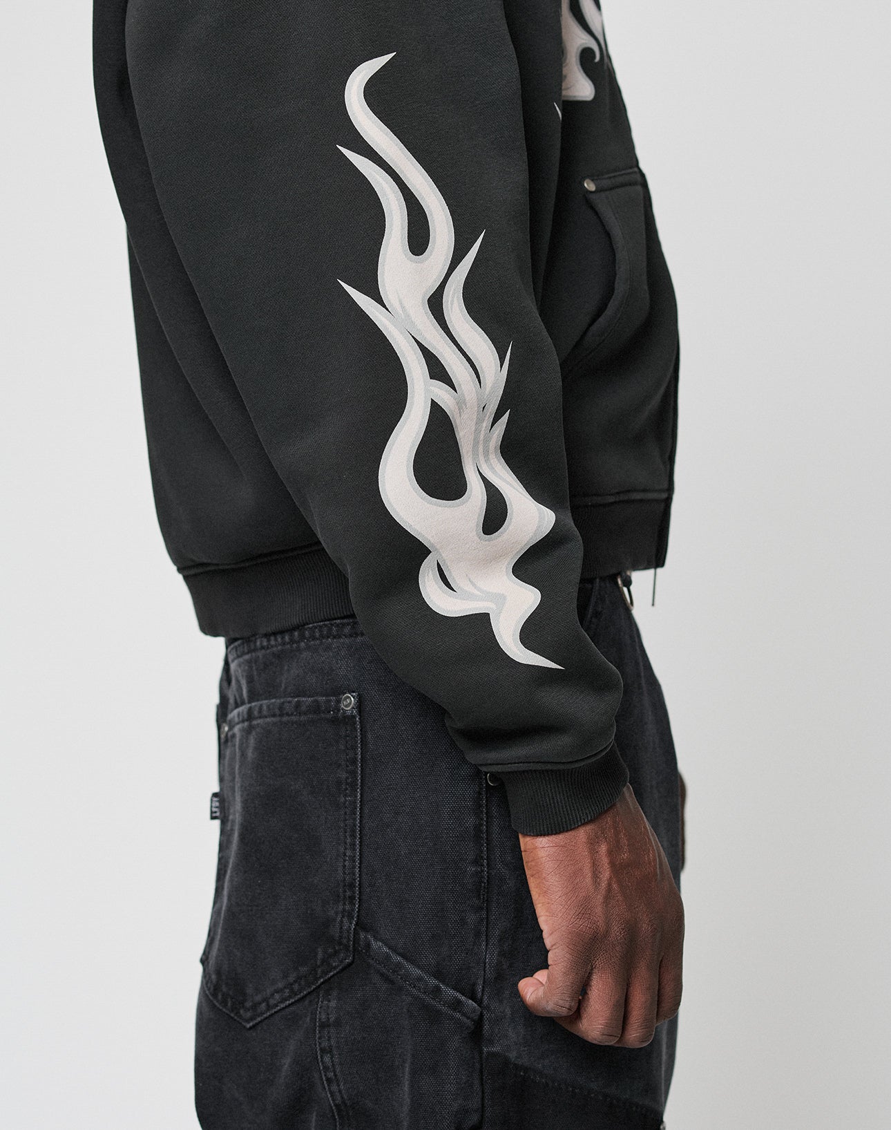 A person wearing the LIVE FAST DIE YOUNG LFDY Inferno Hooded Zip with black jeans, shown from the side against a plain light background.