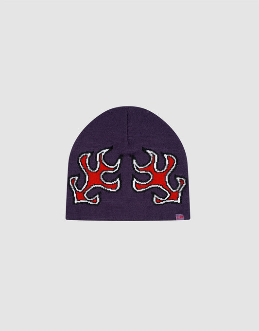 The LFDY Flames Beanie by LIVE FAST DIE YOUNG is a purple Polyacryl hat with two red and white Jacquard flame designs on the front, a subtle Flaglabel, and is shown against a light gray background.