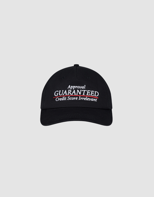 The LFDY Guaranteed Cap by LIVE FAST DIE YOUNG is an unstructured 5-panel black cap made of 100% polyester, featuring "Approval GUARANTEED Credit Score Irrelevant" embroidered in white and red, and an adjustable Snapverschluss. Displayed on a gray background.