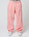 Person wears loose-fitting pink Basic Wide Jogger sweatpants by LIVE FAST DIE YOUNG with an elastic drawstring waist and a white logo waistband, paired with white sneakers. Image is cropped above the waist; plain, light background.