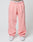 Person wears loose-fitting pink Basic Wide Jogger sweatpants by LIVE FAST DIE YOUNG with an elastic drawstring waist and a white logo waistband, paired with white sneakers. Image is cropped above the waist; plain, light background.