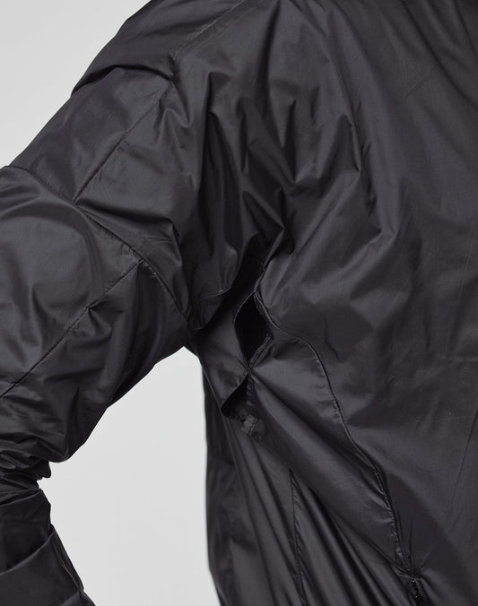 A close-up shows a person wearing the black, shiny Live Fast Performance Running Jacket by LIVE FAST DIE YOUNG. The Regular Fit jacket’s seams are visible on the arm and side, set against a plain light background.