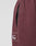 Close-up of maroon LIVE FAST DIE YOUNG Wide Cuff Jogger in 100% Baumwolle, showing a vertical zippered pocket and part of a white cursive "Fast" logo. Features a wide fit against a plain light gray background.